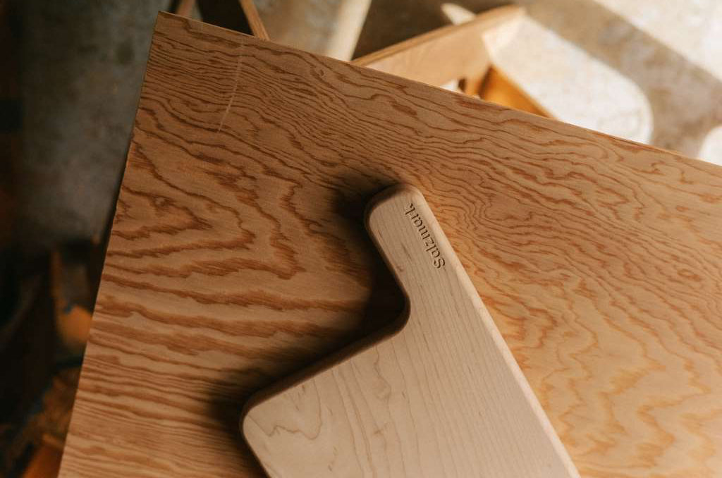 Close-up of a cutting board with 'Salzmak' branding on a blurred background